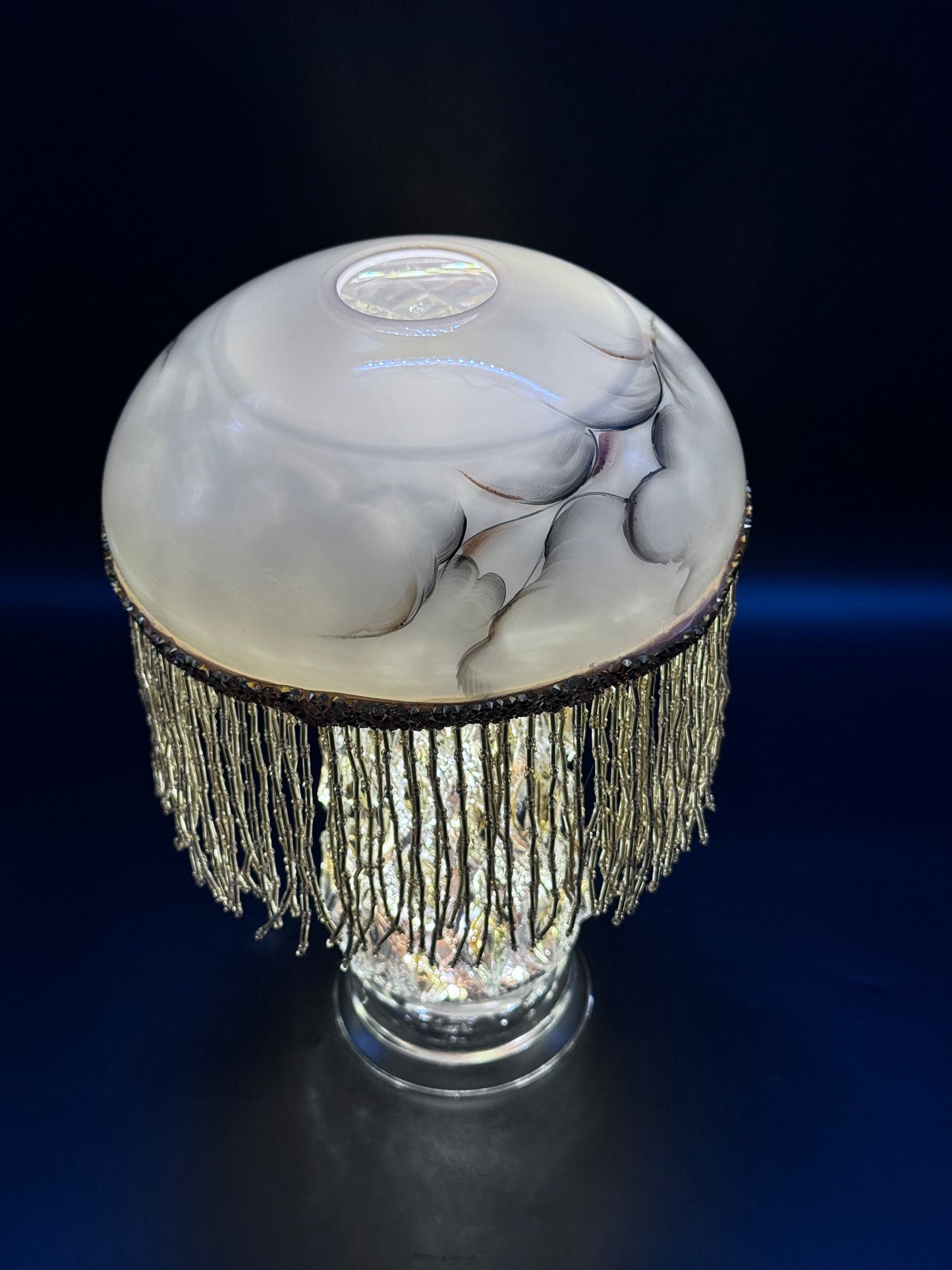Vintage lyslenkelampe med champagnefot og kremfarget kuppel med frynser