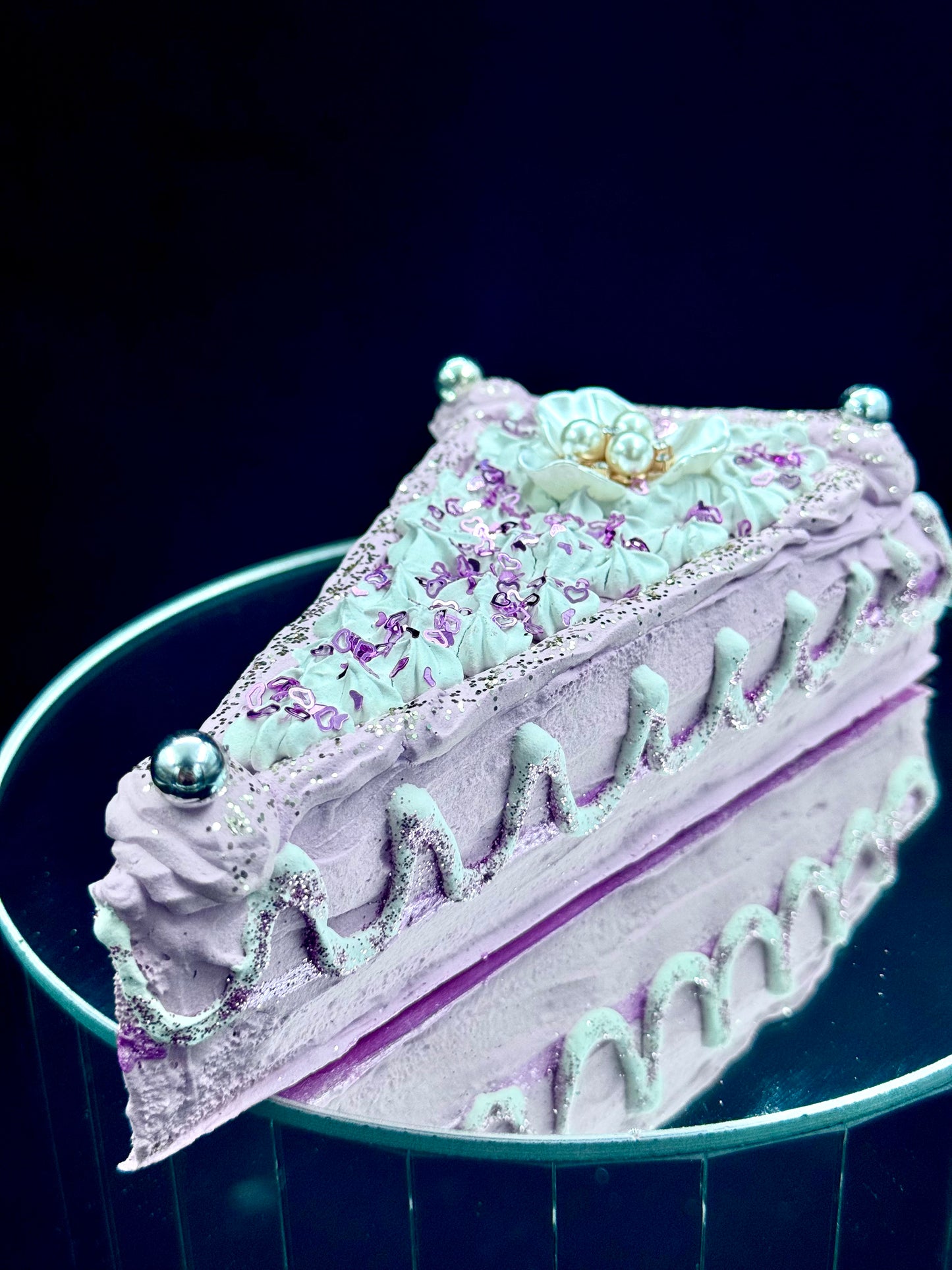 Stort kakestykke i lys rosa med krem og perler