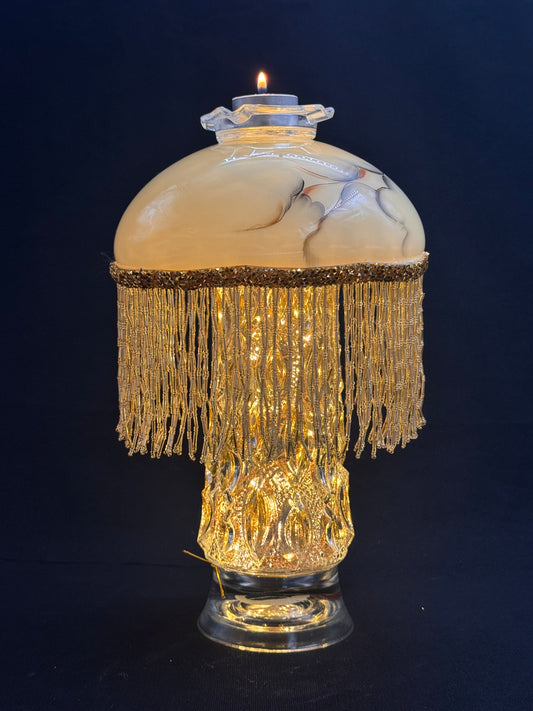 Vintage lyslenkelampe med champagnefot og kremfarget kuppel med frynser