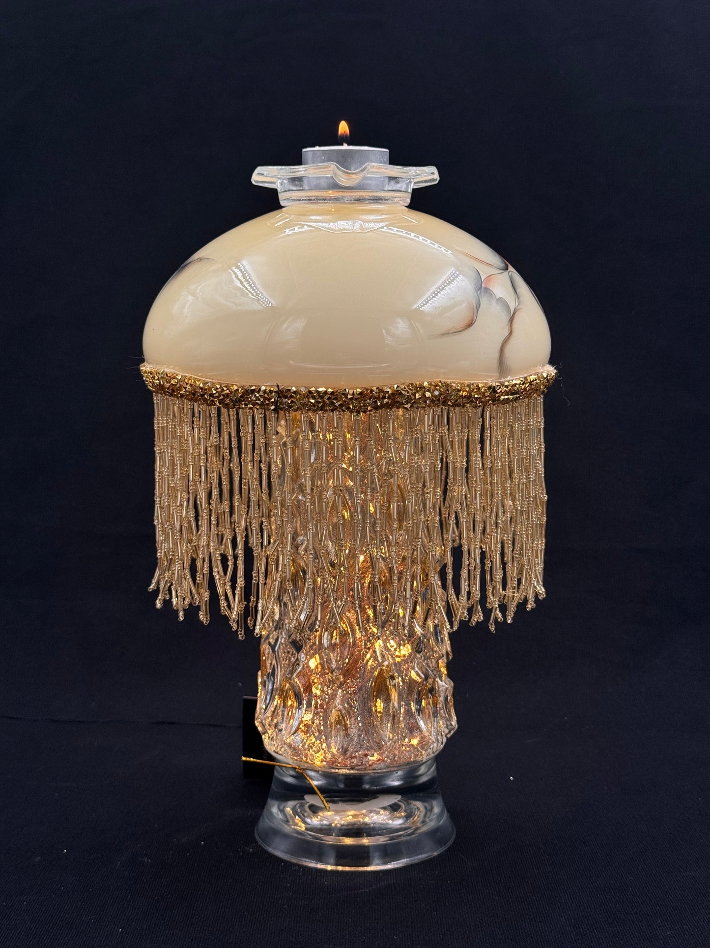 Vintage lyslenkelampe med champagnefot og kremfarget kuppel med frynser