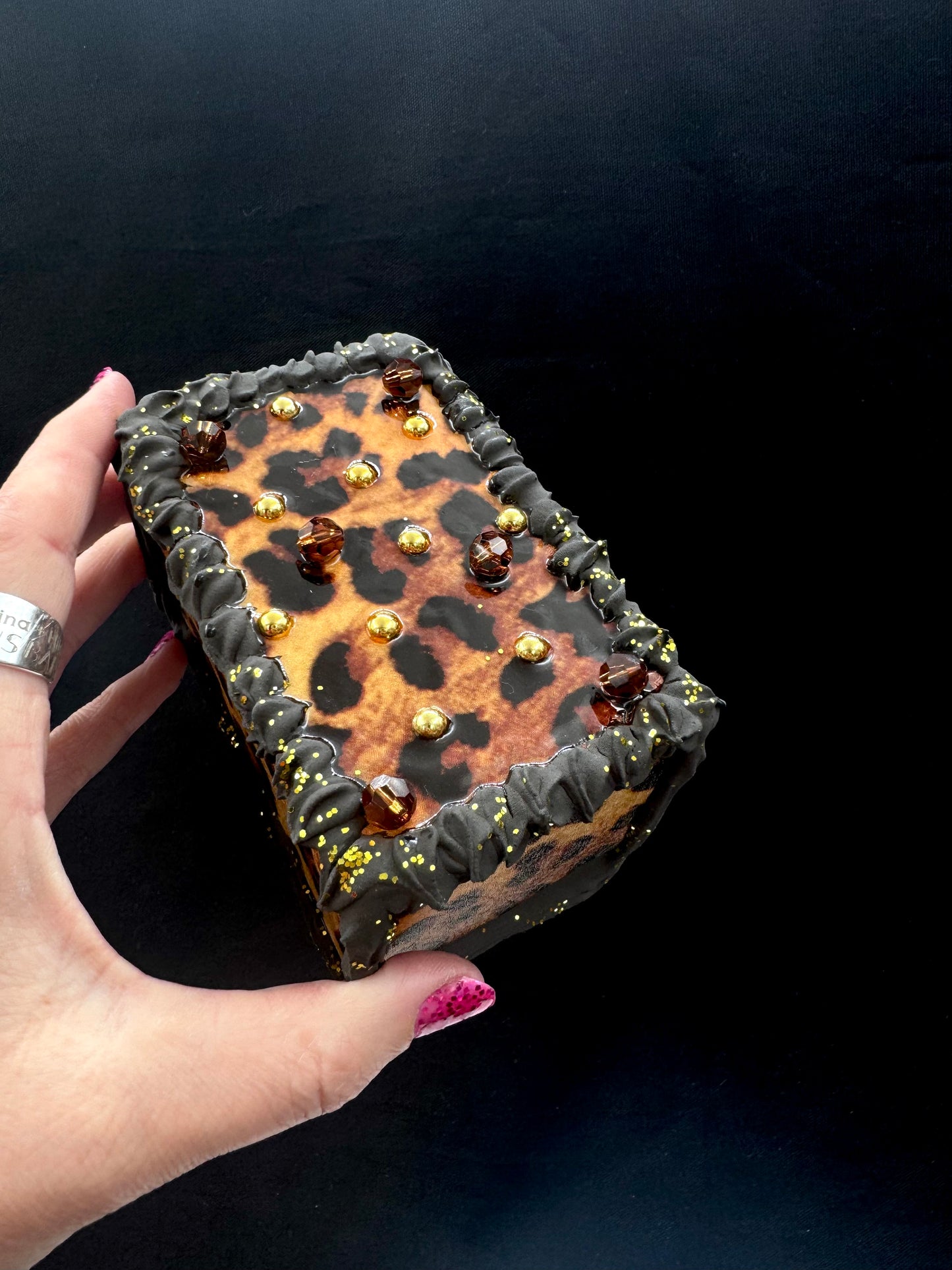 Firkantet kakestykke i brun leopard med krem og gullperler