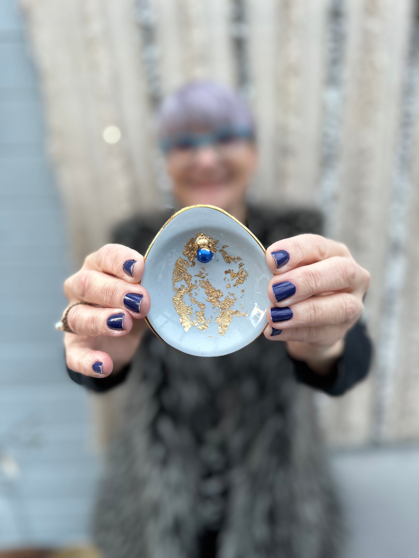 Vulvakunst med glassfot og babyblått fat med kongeblå perle