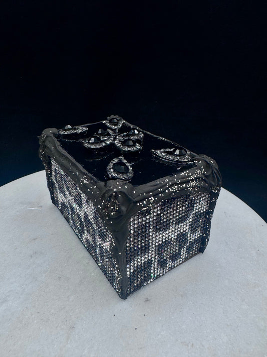 Firkantet kakestykke i svart med krem og leopardglitter