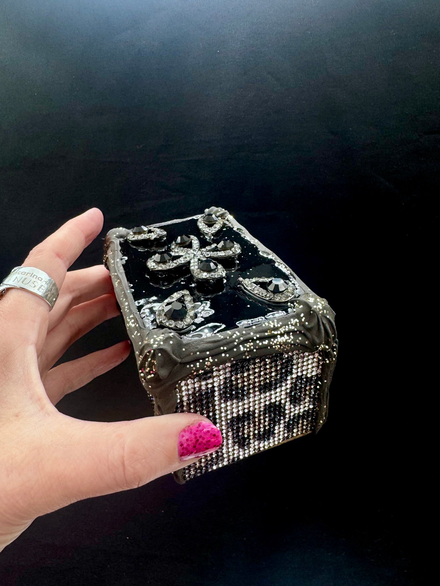 Firkantet kakestykke i svart med krem og leopardglitter